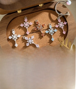 Detail of silver cross pendants with colorful cubic zirconia in a wooden jewelry box