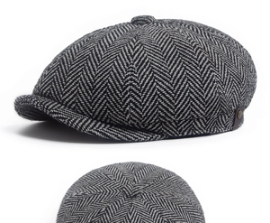 Detail view of the classic grey herringbone pattern and metal button on the newsboy cap