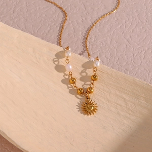 Golden sun pendant necklace with freshwater pearls in a retro bohemian style design