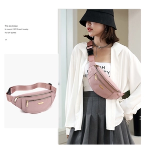 Detail showing pink nylon waist bag with multiple zippers and adjustable strap on model
