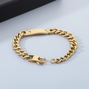 Close-up of a polished gold stainless steel Cuban chain bracelet with a blank ID plate
