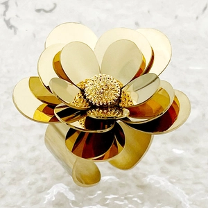 Macro shot of gold floral ring with layered petals and textured metallic details