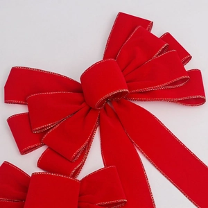 Detail of red velvet Christmas bow with gold stitching on clean white background