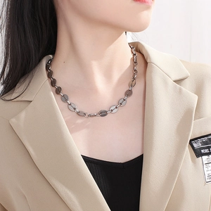 Minimalist silver stainless steel pig nose chain necklace on model in beige blazer