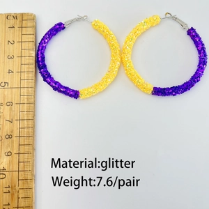 Macro detail of 6cm purple and gold glitter hoop earrings showing diameter and 7.6g weight