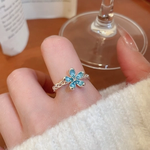 Detailed macro view of a blue flower ring with crystal core and braided silver band