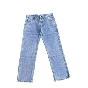 Flat lay of light blue straight denim jeans showing classic texture and fit