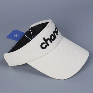Detail showing UPF 50+ sun protection tag and wavy knit texture on a cream sun visor hat