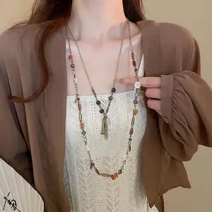 Collana vintage a doppio strato con monete di bronzo, pietre naturali e nappe