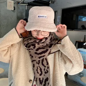 Close-up of stylish leopard print knitted scarf paired with beige lamb wool bucket hat
