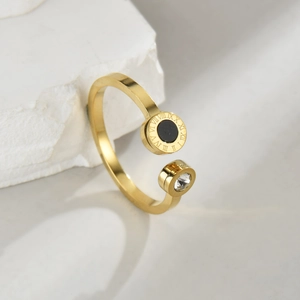 Detail eines goldenen geometrischen Rings mit römischen Ziffern und rundem Edelstein