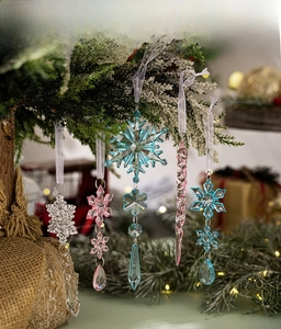 Macro detail of acrylic colorful snowflake and icicle ornaments hanging on a Christmas tree
