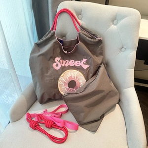 Detail of brown nylon tote with pink Sweet embroidery and matching zipper organizer pouch