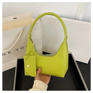 Detailed close-up of bright green crocodile pattern on crescent shaped underarm bag