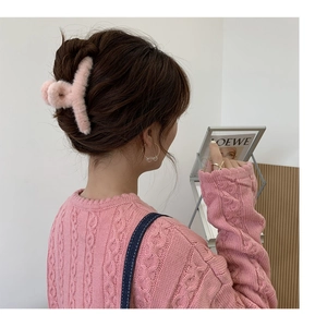Rückansicht einer rosa Plüsch-Haarklammer, getragen von einem Modell in Innenräumen