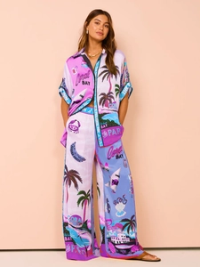 Close-up of tropical floral print on a silky two-piece lounge set in purple and blue