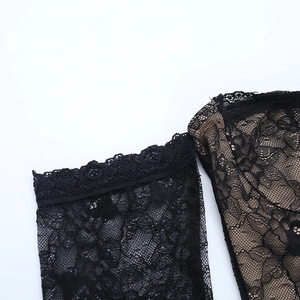 Gros plan sur la dentelle florale noire élégante avec doublure nude sur la robe