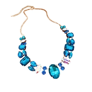 Irregular geometric necklace with blue and white crystals on a gold chain