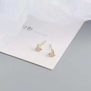 Close-up of gold stud earrings with round and marquise-cut zircons on a white display card
