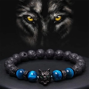 Detailed view of beaded wolf head bracelet with tiger eye and lava stones on black stand