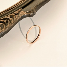 Detailed view of faceted rose gold titanium steel ring with sparkling light reflections