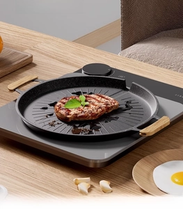 Detail of non-stick electric grill pan with wood handles and textured cooking surface
