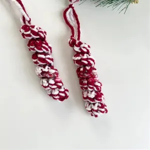 Detail of red and white spiral knitted Christmas tree ornament with green pine decor