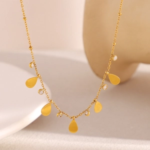 Vue détaillée des pendentifs en zircon goutte plaqués or 18K sur un collier à billes
