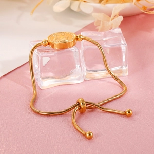 Detailed view of adjustable golden coin pendant snake chain bracelet on ice display
