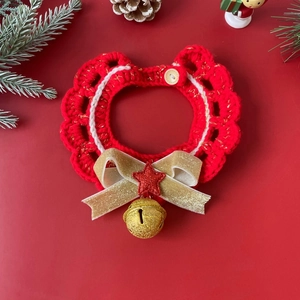 Detail of red knit pet collar with gold bow and bell for Christmas holiday season