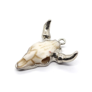 Detailed view of resin bull skull pendant with silver-plated horns and metal ring loop
