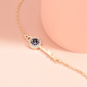 Minimalist evil eye key pendant necklace in gold with blue and white zircon stones