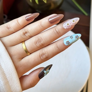 Detail of almond-shaped press-on nails with 3D floral carving and brown plaid patterns