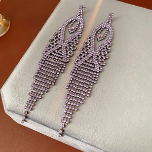 Detailed shot of purple crystal tassel earrings with gunmetal rhinestones on velvet tray