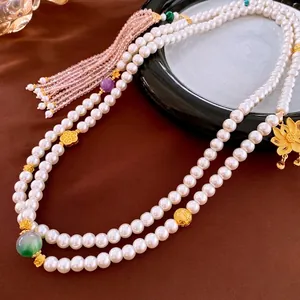 Elegant gold-plated lotus pearl necklace with colorful beads on dark satin background