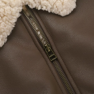 Detailed close-up of brown PU leather texture and cream faux fur collar with metal zipper