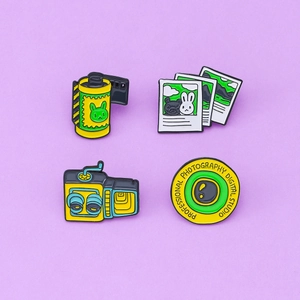 Set of four vintage camera and film enamel pins featuring cartoon rabbit and bear motifs