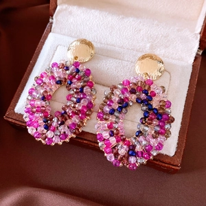 Detail of beaded oval earrings with glass beads in a velvet jewelry display box