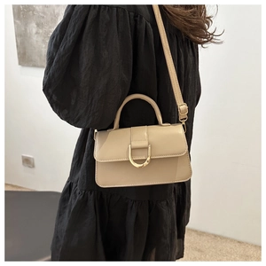Dettaglio della borsa beige in ecopelle con distintiva fibbia a D in metallo dorato