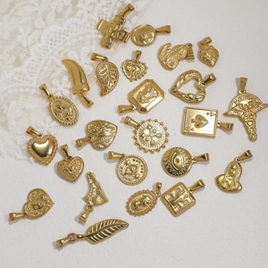 Collection of gold stainless steel pendants featuring hearts, leaves and vintage icons