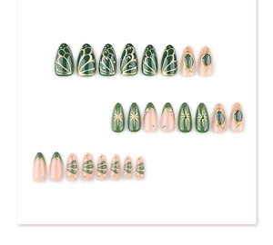 Detail of bohemian press-on nails with green base, gold butterflies and gem accents