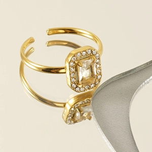 Macro view of gold plated adjustable ring featuring a rectangular zircon and pavé setting