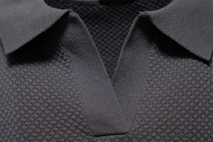 Detailed macro view of high-quality knit texture and V-neckline on dark gray polo shirt