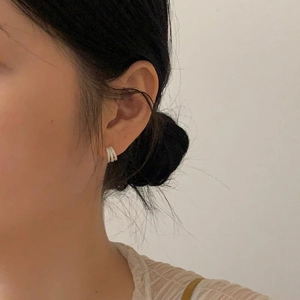 Close-up of triple-layered S925 sterling silver hoop earrings with cubic zirconia on model