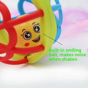 Gros plan du hochet pour bébé avec balle souriante jaune produisant un son en le secouant