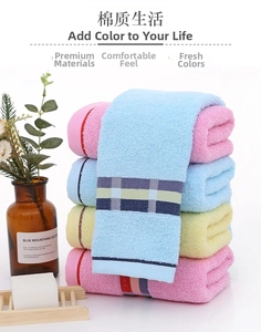 Close-up of stacked colorful cotton towels with striped edges and home decor accents