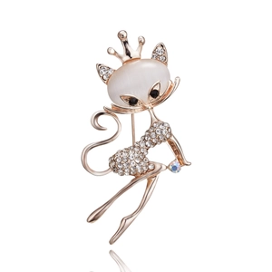 Close-up of rose gold cat brooch with opal head, rhinestones and a small crown