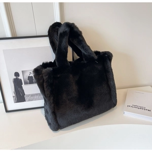 Close-up of fluffy black faux fur tote bag with plush handles and soft texture