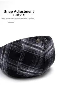 Detail of adjustable metal snap buckle on vintage plaid flat cap for custom sizing