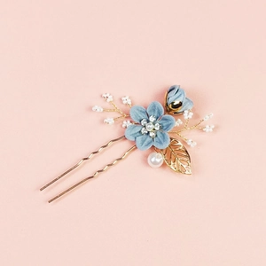 Peigne à cheveux de mariée avec feuille dorée fleur bleue et perles sur fond rose